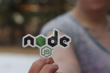 A Node.js sticker held between two fingers